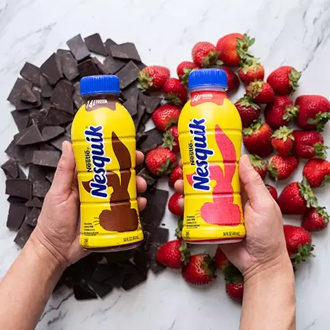 Nesquik bottles over chocolate and strawberries