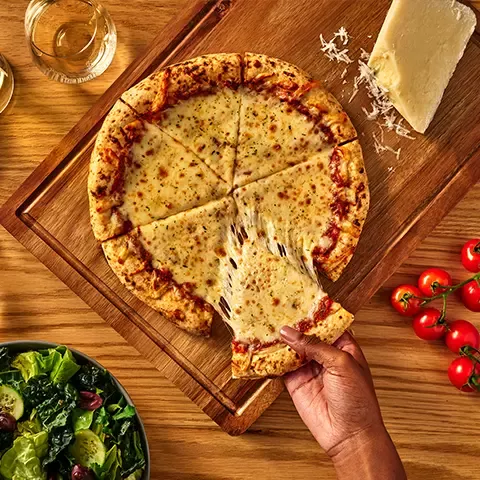 DiGiorno Wood Fired Pizza on cutting board with ingredients