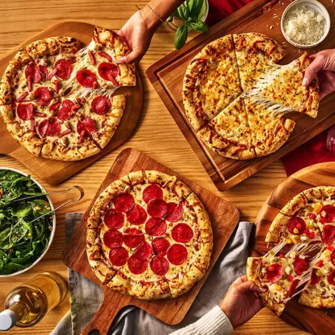 DiGiorno Wood Fired Pizzas on dining table with salad